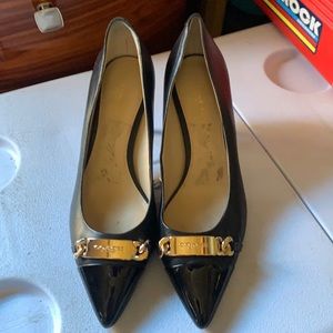 Black and gold coach pumps.